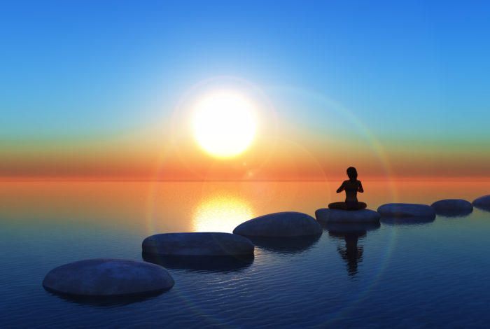 3D render of a female in a yoga pose on stepping stones in the ocean at sunset